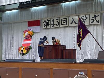 入学式で新入生代表がお祝いを受け取る様子